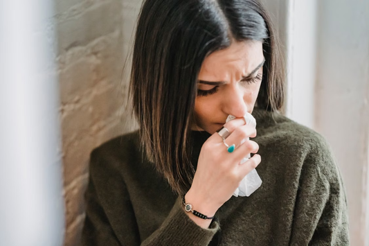  A woman looking uncomfortable while struggling with a stuffy nose.