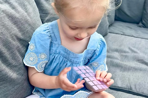 Toddler holding NatPat UV-detection stickers.