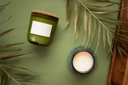 Two scented candles on a green surface 