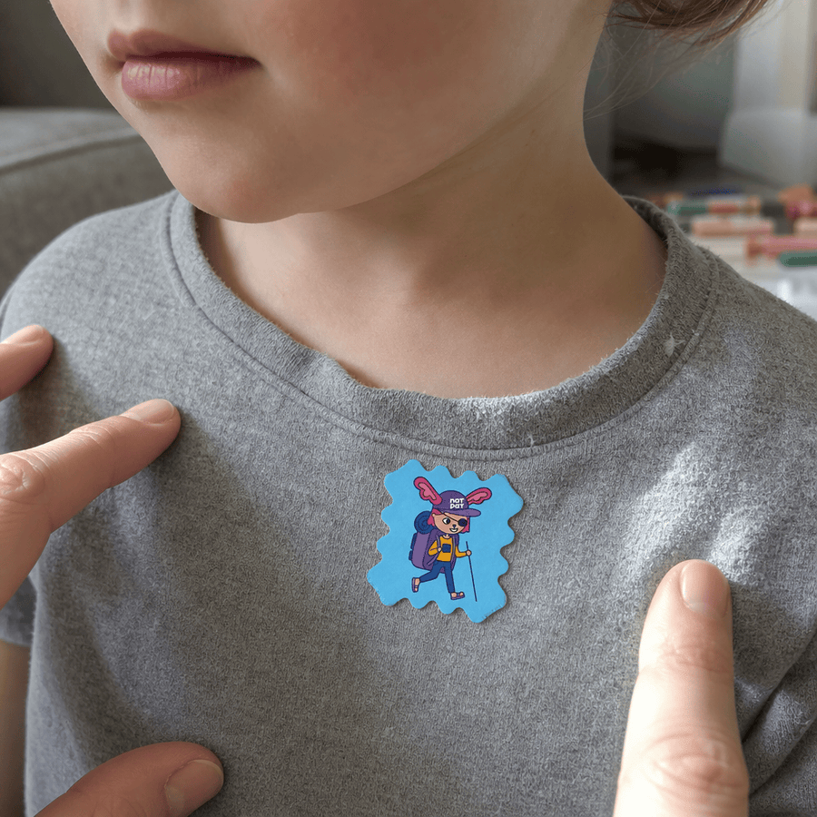 A toddler sleeping peacefully with a StuffyPatch sticker on their pajama collar.