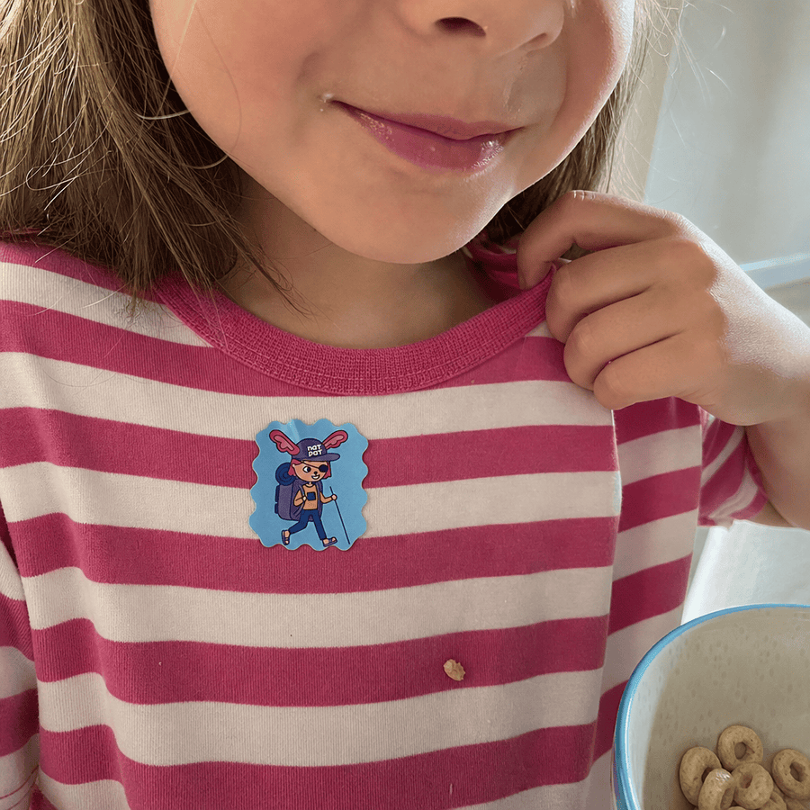 A parent applying a StuffyPatch sticker to their child's collar as cold season begins.