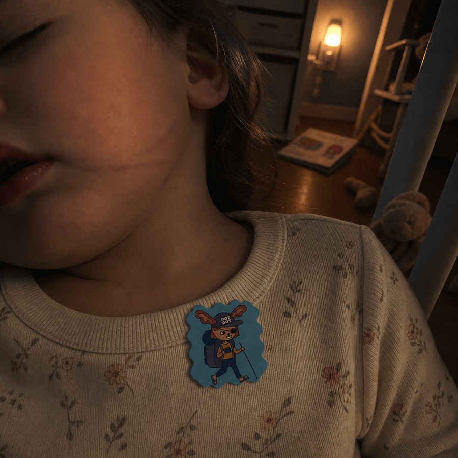 A parent tucking a sleeping child into bed at night, a StuffyPatch sticker on the child's pajama collar, soft nightlight glow.