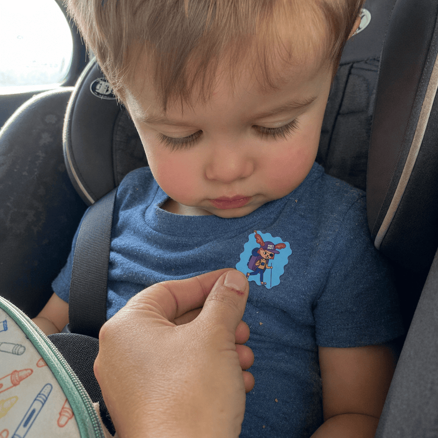 A toddler sleeping peacefully with a StuffyPatch sticker on their pajama collar.