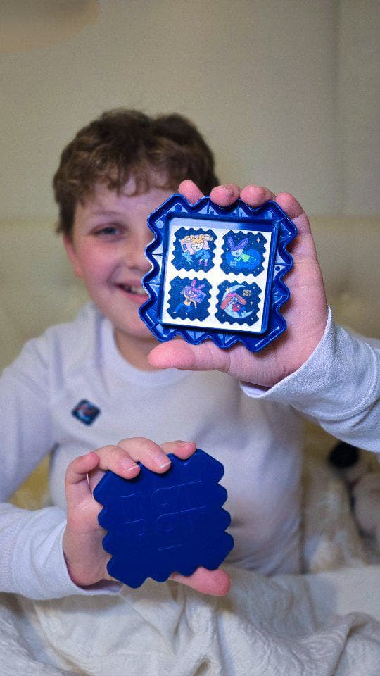 Boy proudly holding his SleepyPatch sticker pack