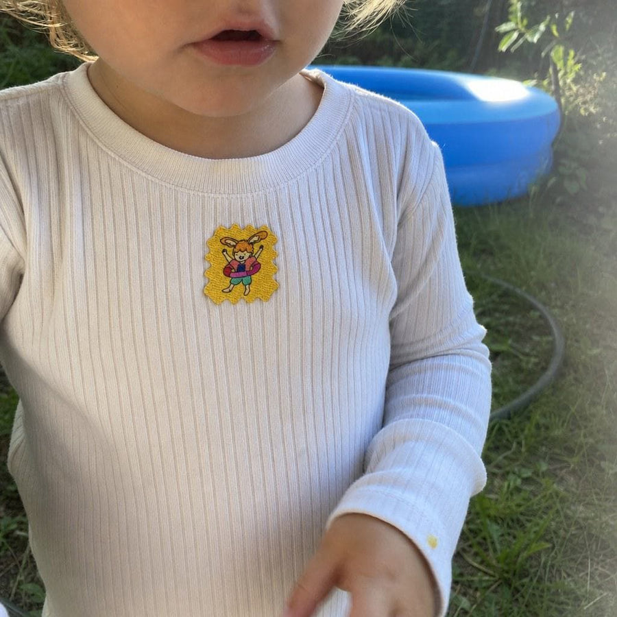 Parent and child on a forest trail, a TrailPatch sticker on the child's shirt.