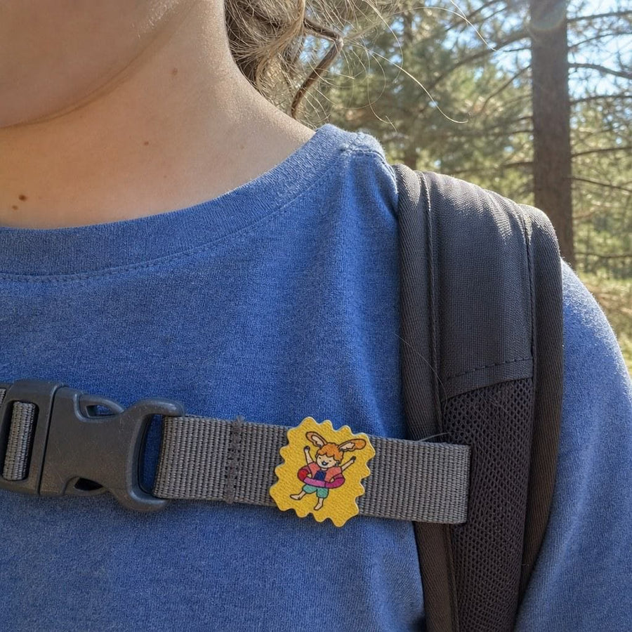 Parent and child on a forest trail, a TrailPatch sticker on the child's shirt.
